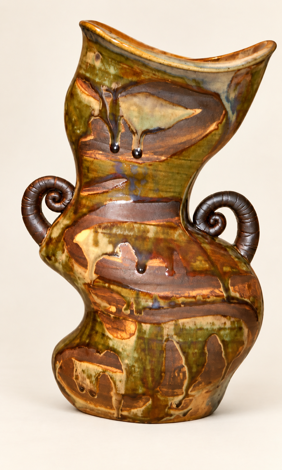 Flowing green and amber sculptural vessel with curled handles
