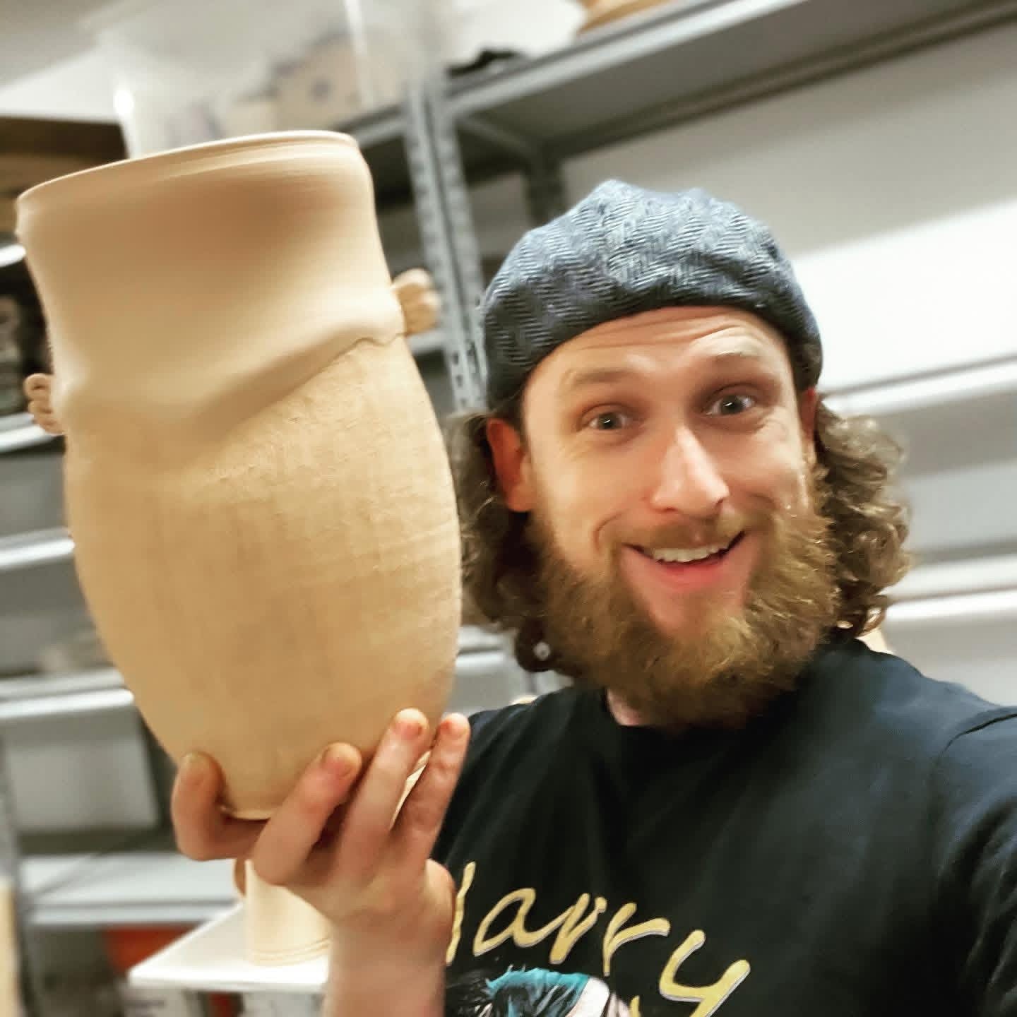 Harrison Hickman holding a freshly thrown vessel in his studio