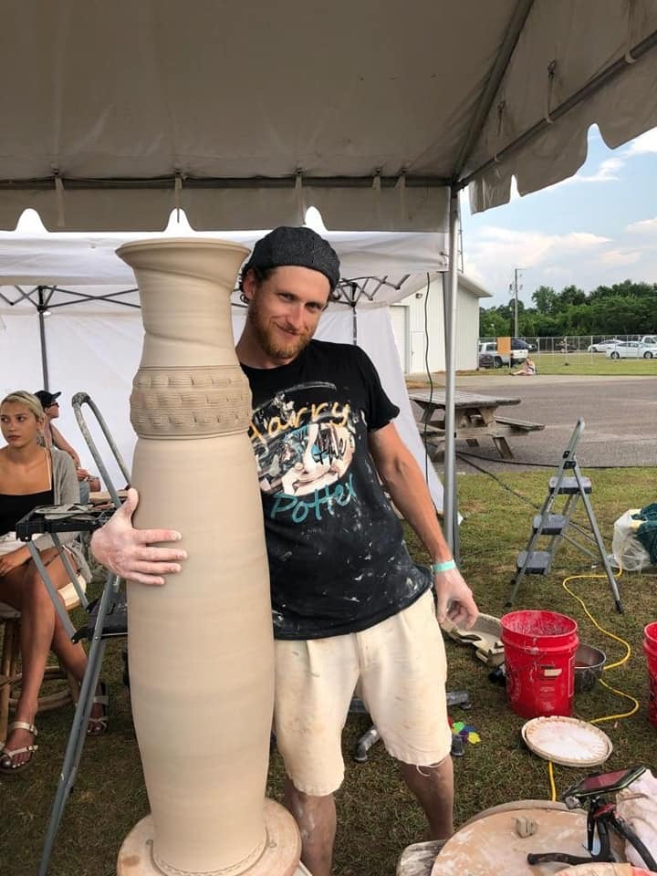 Harrison Hickman beside a large freshly thrown clay vessel