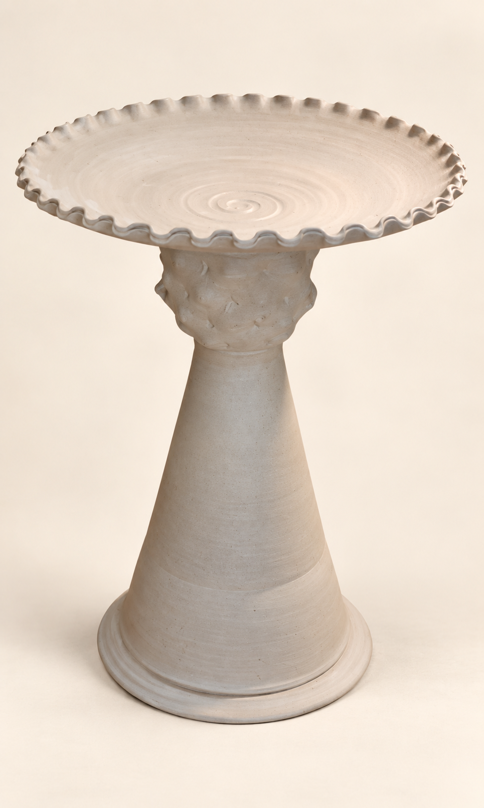Pale scalloped bowl form raised on a curved pedestal